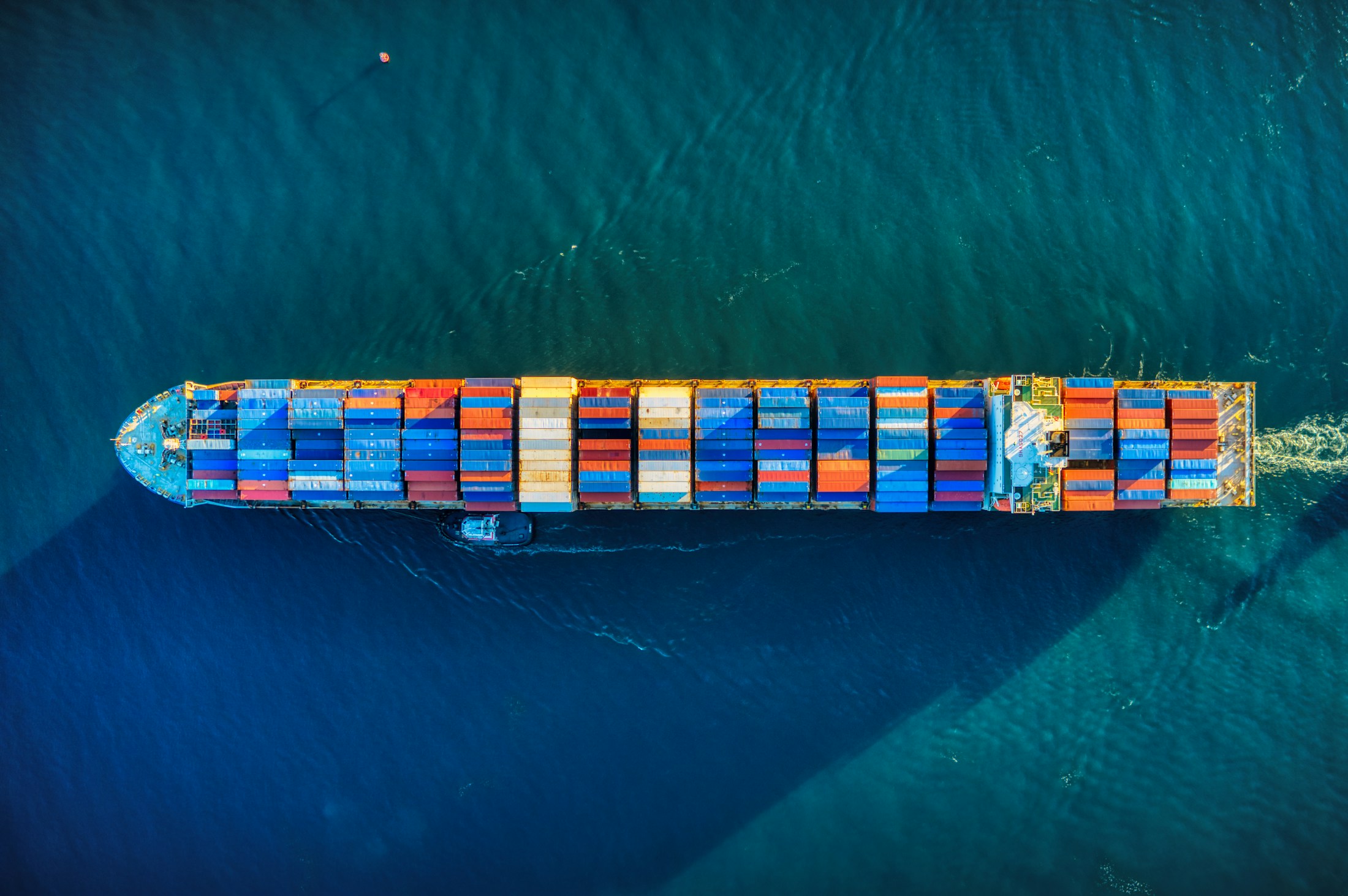 A container vessel moving through turquoise ocean waters